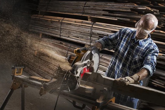 Carpenter cutting with skill saw in workshop to custom wood slab design in Houston Texas
